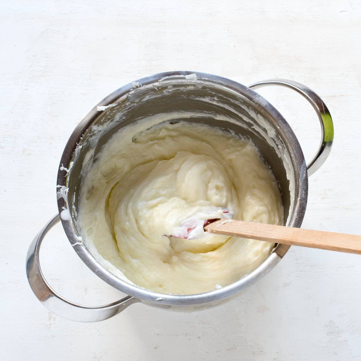 Pudinkový máslový krém připravený k promazání koláče.